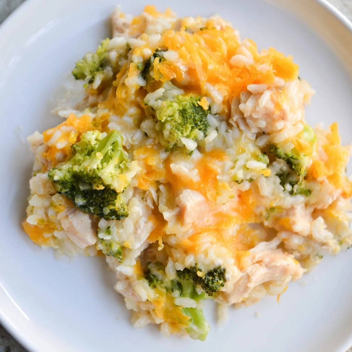 A close-up of a creamy Chicken & Broccoli Rice Casserole, showing tender chicken and fluffy rice.
