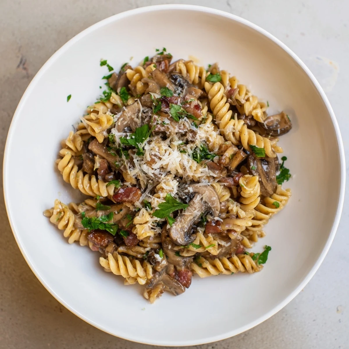Savory fusilli with bacon, onions and mushrooms, perfectly seasoned and ready to serve.