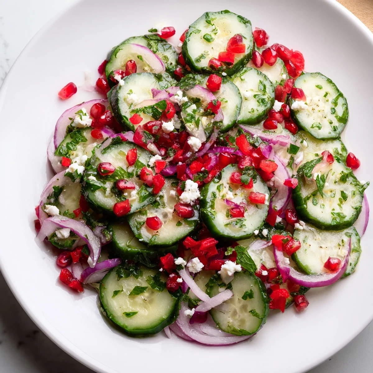 Vibrant Healthy Cucumber Christmas Salad with ruby pomegranate seeds and a bright citrus dressing.