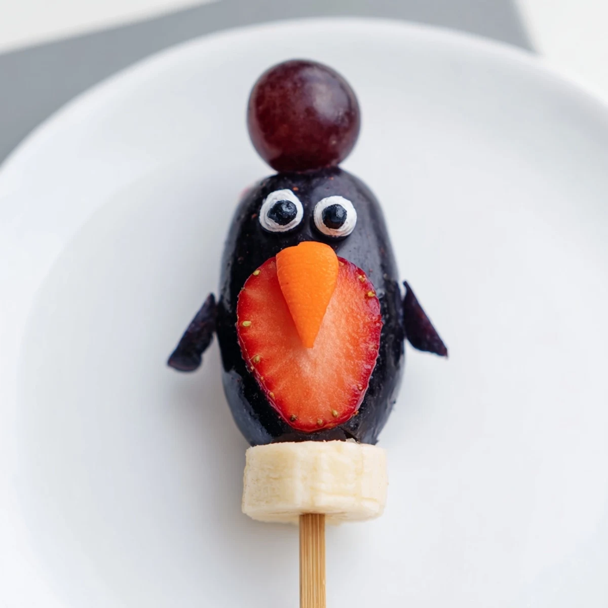 Vibrant Penguin Fruit Skewer Army featuring strawberries, grapes, and blueberries on a fun, colorful platter.