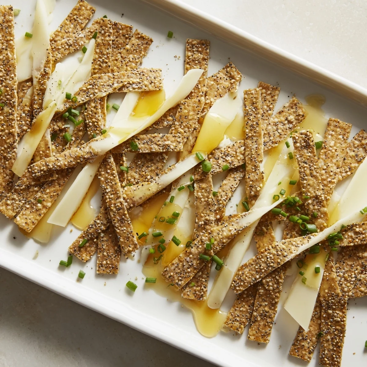 Crispy crackers and layered cheeses create a delicious Garden Gate Lattice appetizer on a platter.