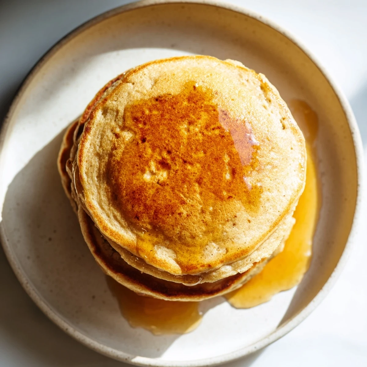 A stack of delicious, light and healthy Protein Banana Pancakes, cooked to a perfect golden brown.