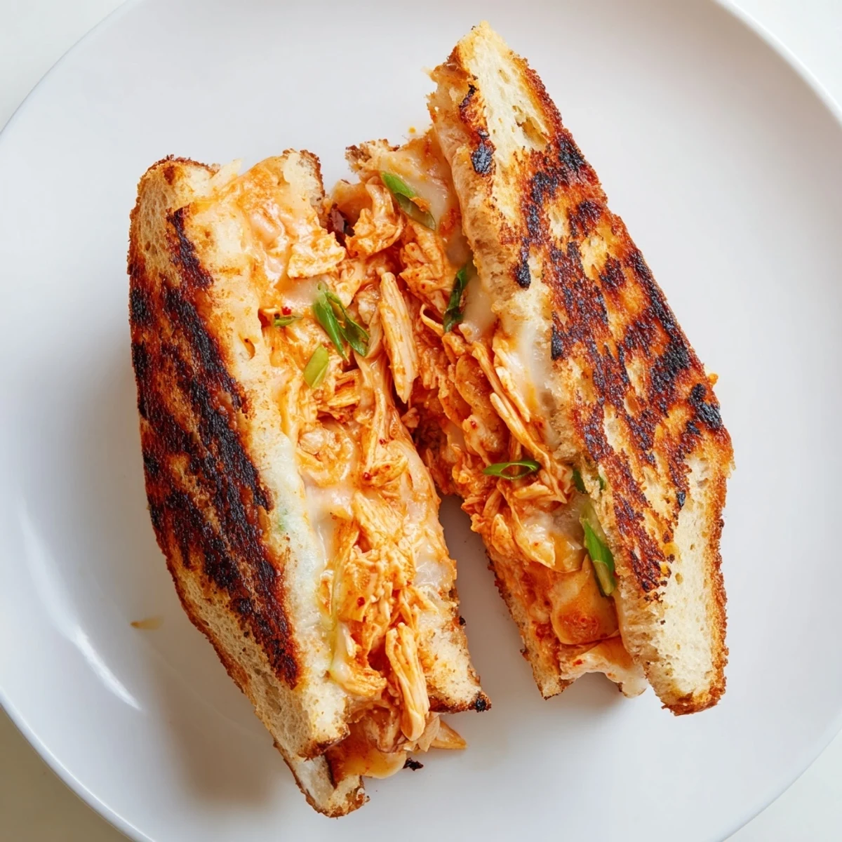 Golden, crispy Gochujang Mayo Chicken Sandwich grilled cheese with melted cheese and spicy chicken filling.