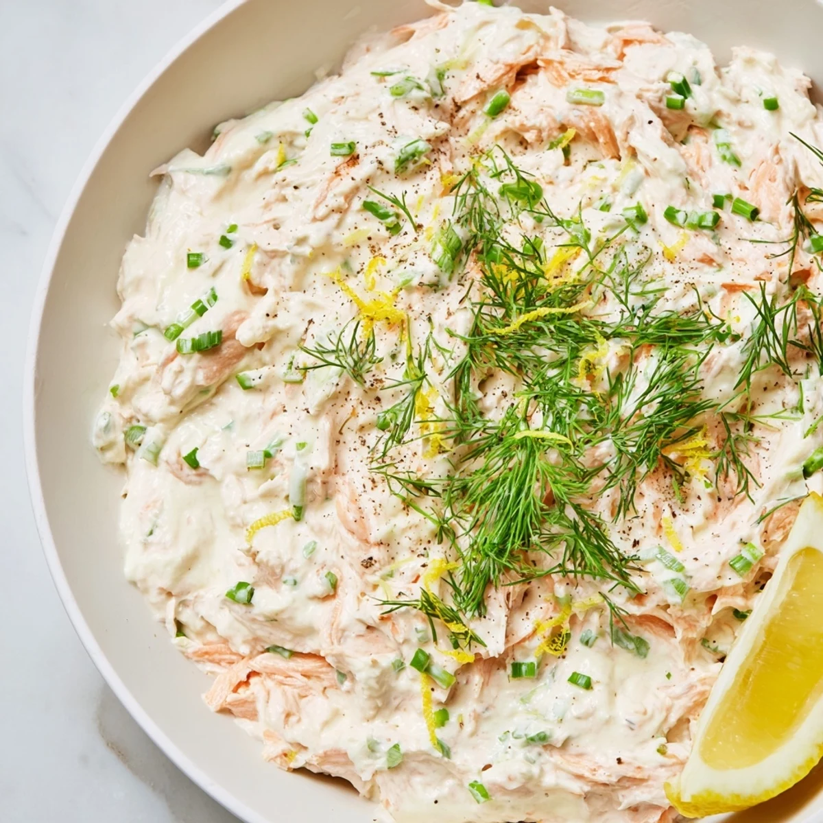 Creamy smoked salmon dip, a delightful appetizer with vibrant green herbs and smoky salmon.