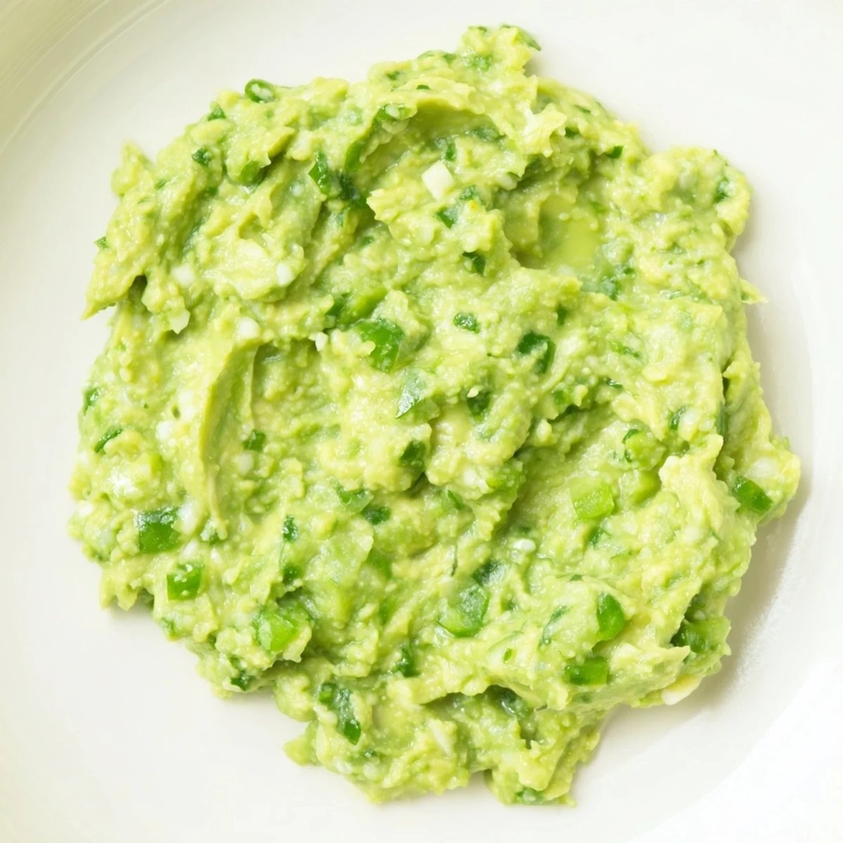 Fresh, vibrant Avocado Lime Dip, chunky and green, ready to be scooped up with tortilla chips.