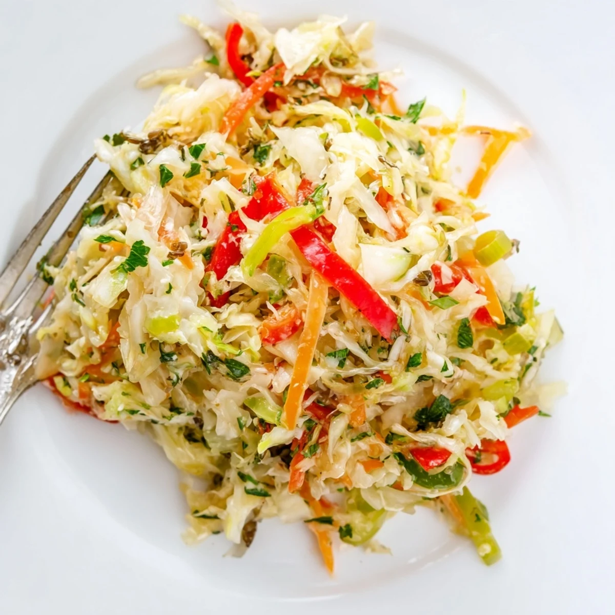 Crunchy sauerkraut slaw with fresh carrots and bell peppers, tossed in a tangy apple cider vinaigrette for a vibrant vegan side dish.