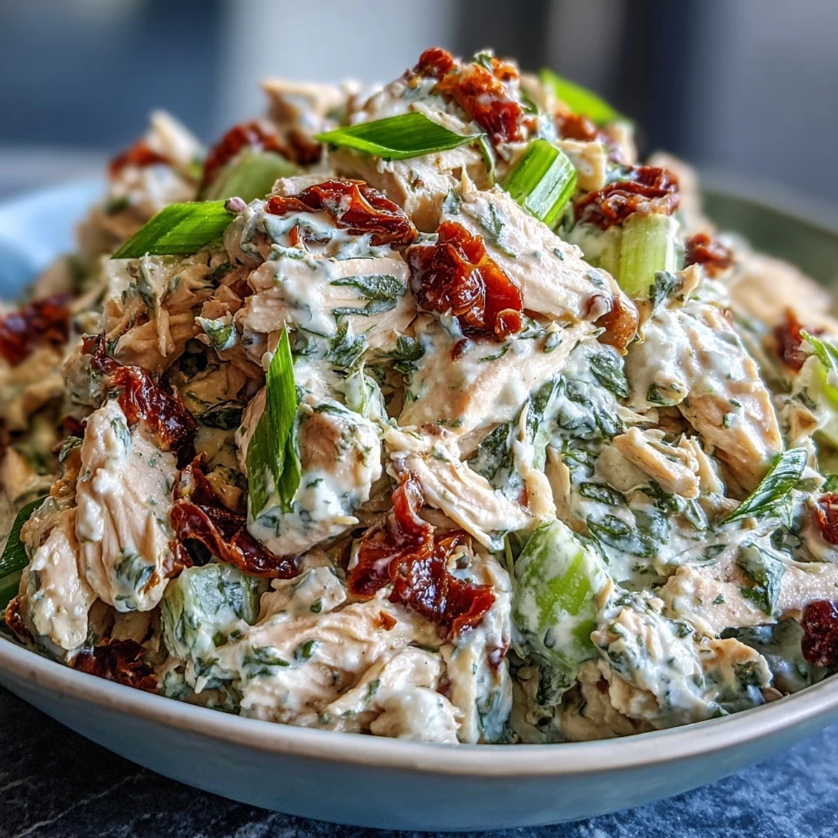 Creamy Sun-Dried Tomato Chicken Salad with shredded chicken and sun-dried tomatoes, ready to serve on toasted sandwich bread.