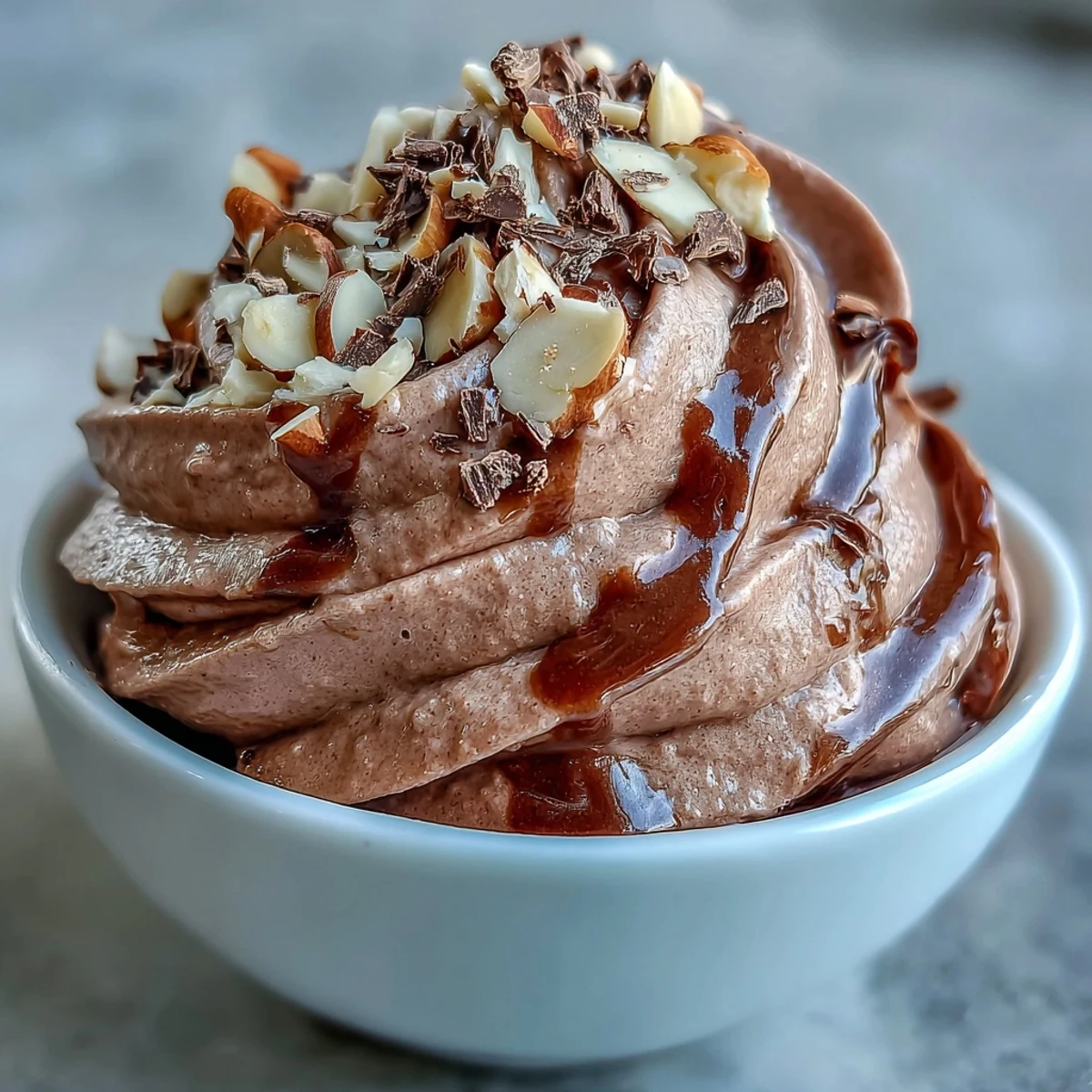 A healthy scoop of Vegan Chocolate Banana Nice Cream with cocoa and almond butter is ready to enjoy from a frozen ripe banana base.