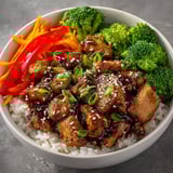 Close-up of Teriyaki Chicken Bowls with Steamed Rice, colorful vegetables, and fluffy white rice.