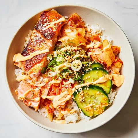 Crispy Salmon Rice Bowl topped with spicy mayo, kimchi, and fresh avocado slices.