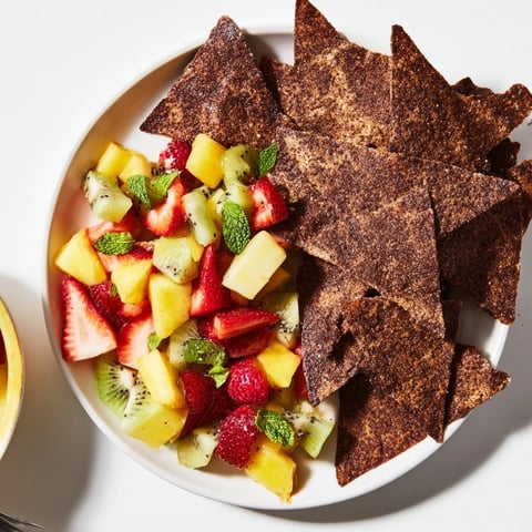Crispy homemade chocolate tortilla chips paired with vibrant fruit salsa, a delightful dessert.  