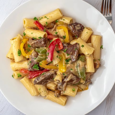 Creamy Philly Cheese Steak Pasta topped with fresh parsley and melted cheese.  