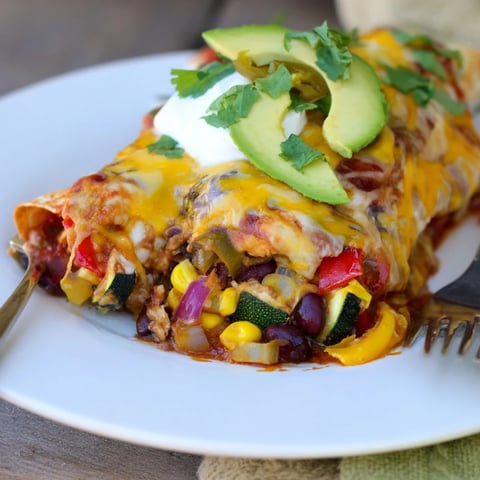 Vibrant Farmers Market Vegetarian Enchiladas topped with gooey cheese and fresh cilantro.  