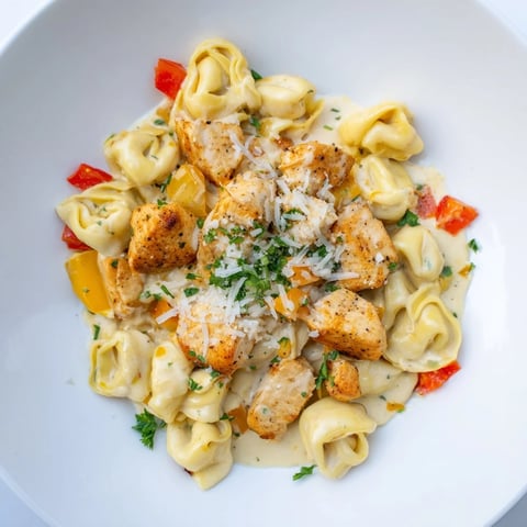 Zesty Cajun Garlic Parmesan Chicken Tortellini, a creamy pasta dish with tender chicken and spicy sauce.