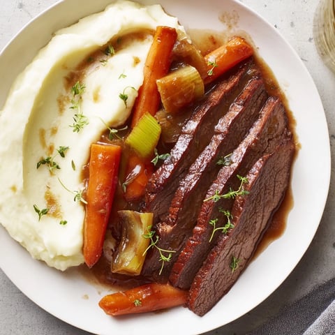 Tender slices of classic brisket, rich with savory sauce, served with creamy mashed sweet potatoes.