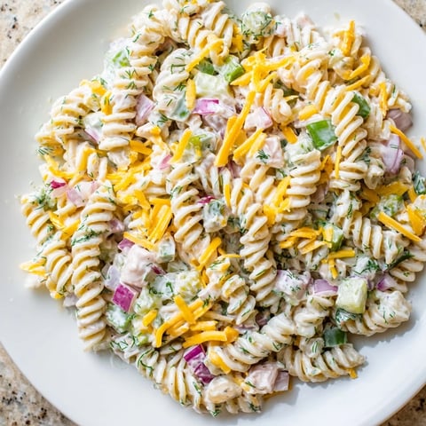 Creamy Dill Pickle Pasta Salad with crunchy pickles, cheddar cheese, and fresh dill ready to serve.