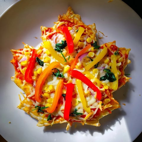 Vibrant Fall Foliage Maple Leaf Mini Pizzas, ready to eat with bubbly melted cheese and colorful veggies.