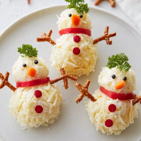 A festive Snowman Cheese Ball Trio, creamy and savory, ready to be served with crackers.