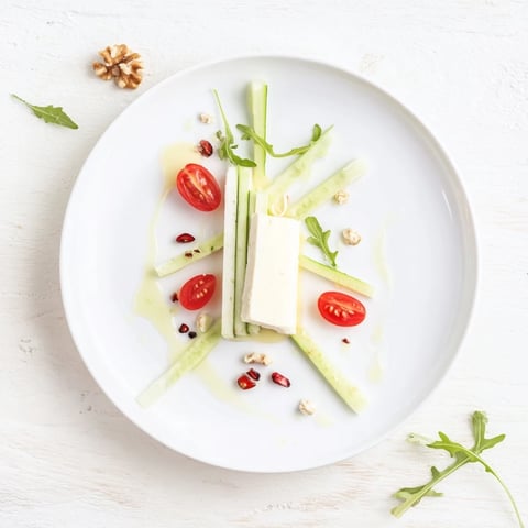 A visually striking Zenith Point salad featuring a creamy artisanal cheese wheel centerpiece.