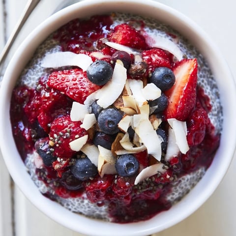 Creamy berry chia pudding layered with fresh berries and coconut flakes, a beautiful breakfast.