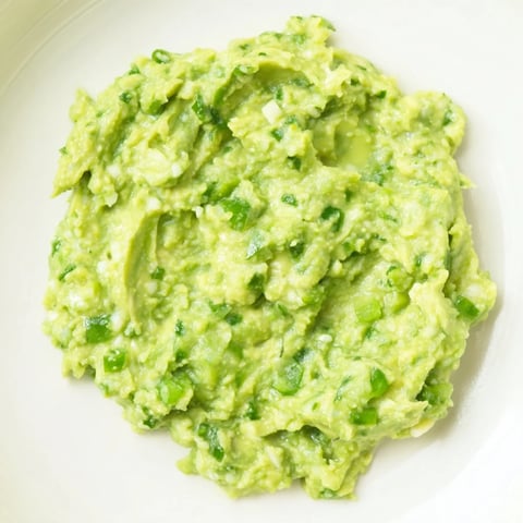 Fresh, vibrant Avocado Lime Dip, chunky and green, ready to be scooped up with tortilla chips.