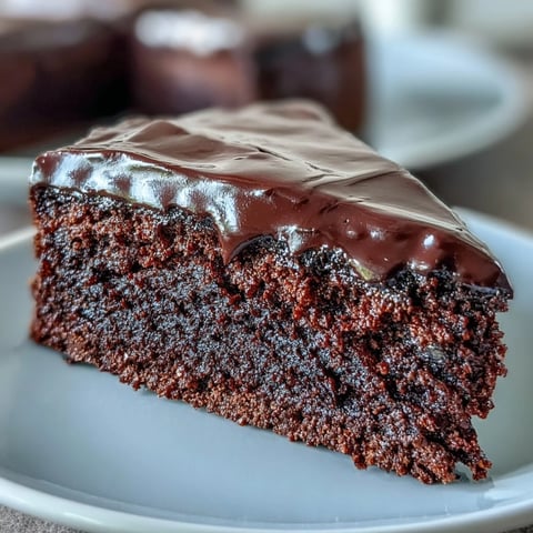 Freshly baked Easy Chocolate Fudge Cake slices reveal a moist, dark crumb topped with glossy, rich chocolate icing.