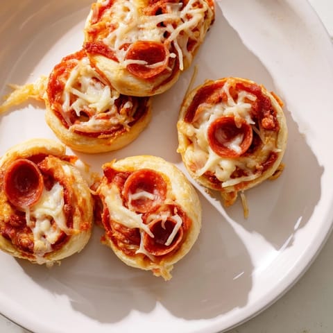 Close-up of baked Mini Pepperoni Pizza Pinwheels with crispy edges, inviting you to take a bite.