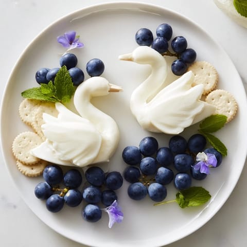 This Elegant Swan Lake Board appetizer presents beautiful swan cheese sculptures surrounded by grapes.