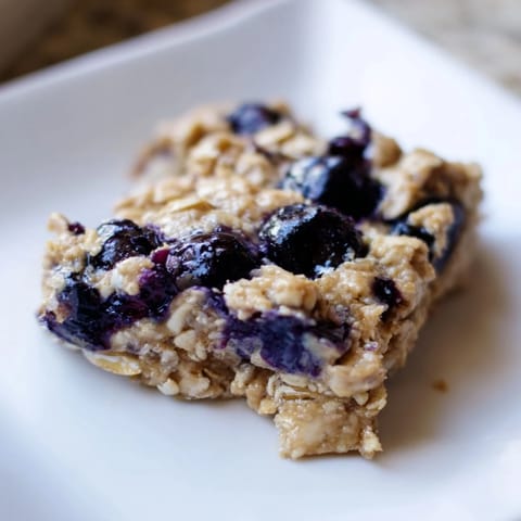 Golden-brown Blueberry Banana Oatmeal Protein Bars, studded with juicy blueberries, ready to eat.