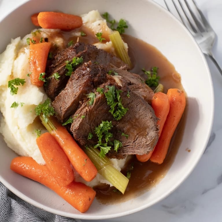 Creamy mashed potatoes alongside juicy Slow Cooker Pot Roast, an ideal dinner for any family.