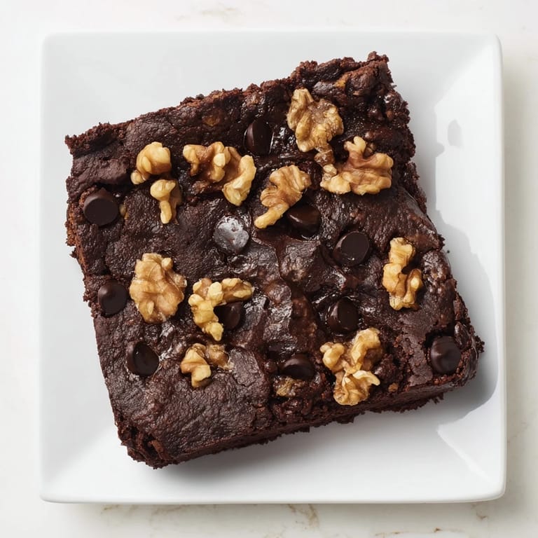 Close-up of decadent sweet potato brownies, showcasing a moist interior with a dusting of cocoa powder.