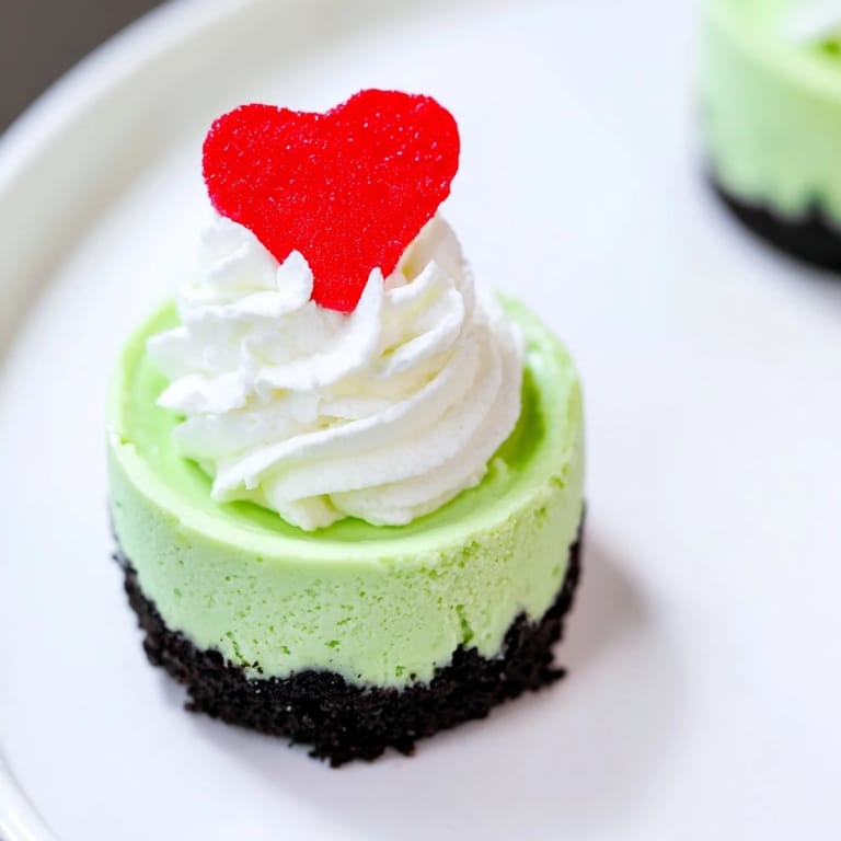 A delightful close-up of Grinch Mini Cheesecakes, ready to enjoy with a delicious Oreo cookie crust.