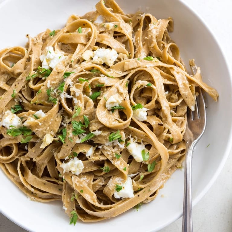Golden-hued, delicious Skinny Alfredo Garlic Parmesan Snowy Pasta, ready to serve with a light garlic-infused cream sauce.