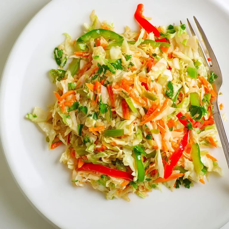 A vibrant sauerkraut slaw topped with fresh parsley, offering a tangy crunch that pairs perfectly with grilled sausages or summer sandwiches.