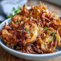 Golden and crispy air fryer onion bhajis with aromatic Indian spices, perfect for a healthy vegan snack.  